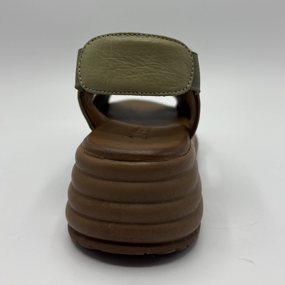 Brown sandal with green strap on a white background