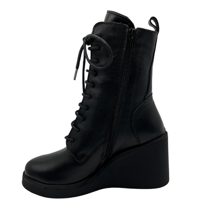 Left facing view of black leather lace up boot with wedge heel and side zipper closure