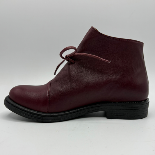 A single burgundy leather ankle boot with a low black block heel and a matching burgundy lace, shown in a side profile against a light gray background.