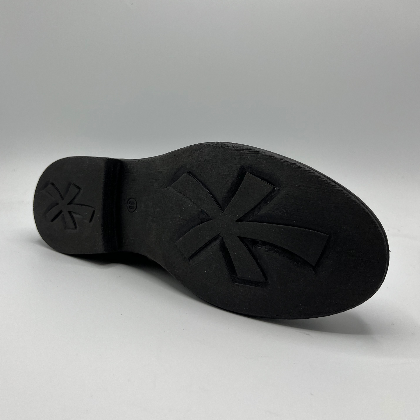 Black shoe sole with a brand logo on a gray background