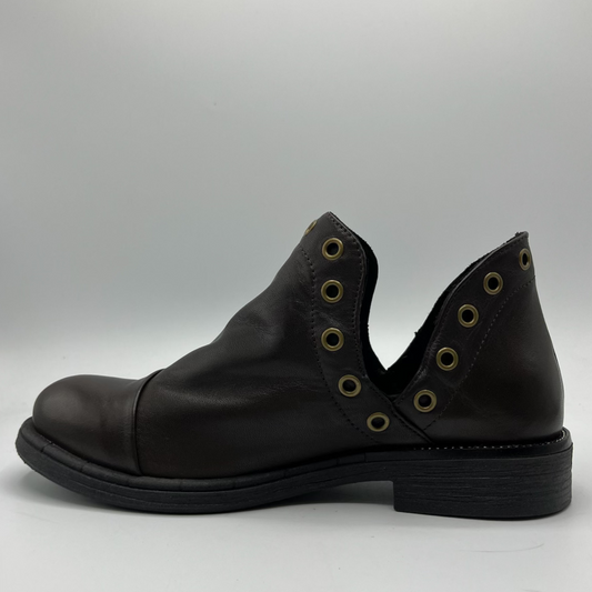 Black leather shoe with eyelets on a gray background