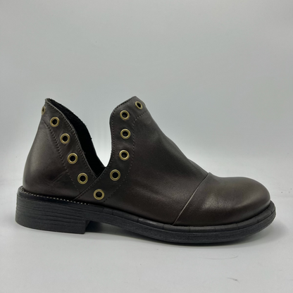 Brown leather shoe with grommet details on a gray background