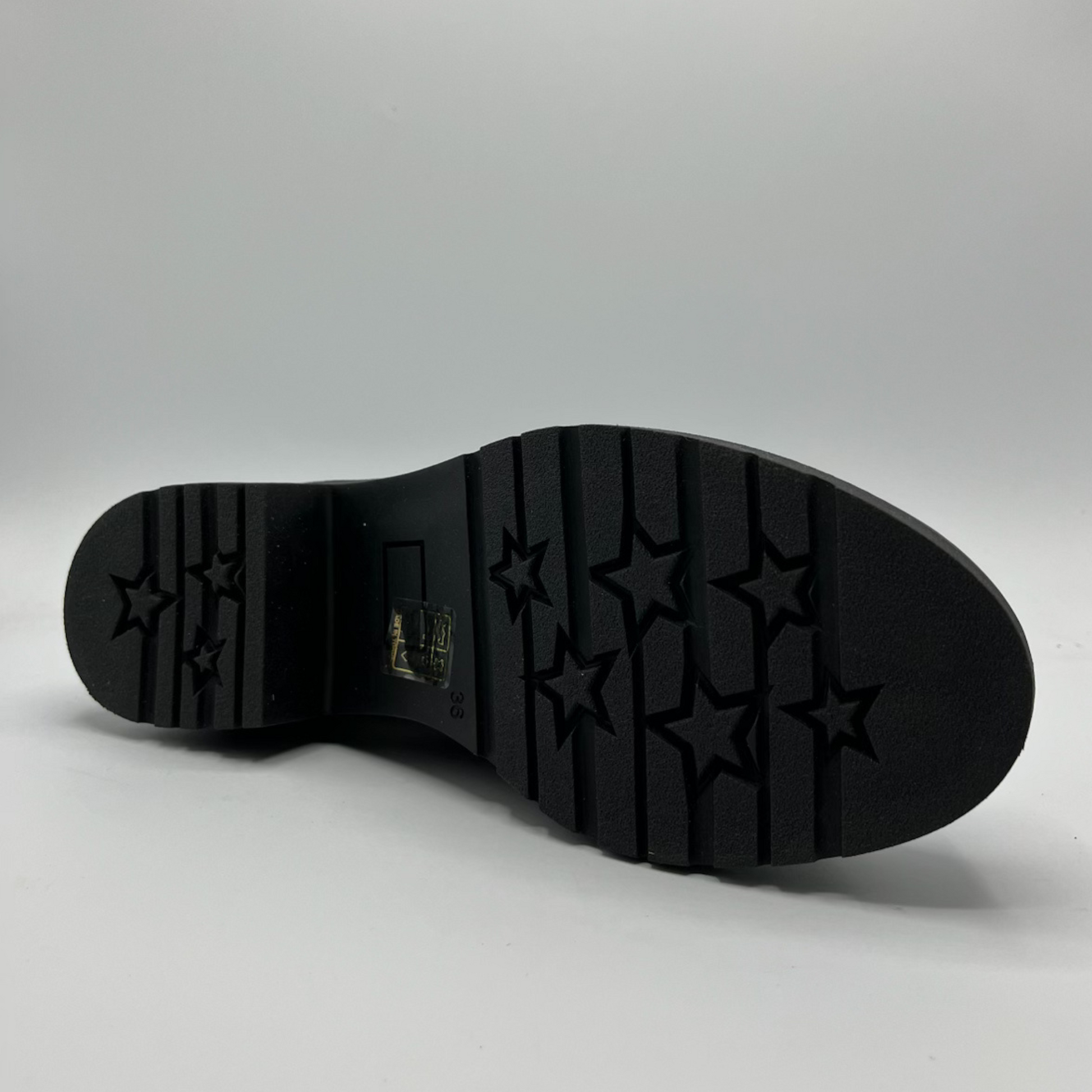 Black sole of a shoe with star patterns on a gray background