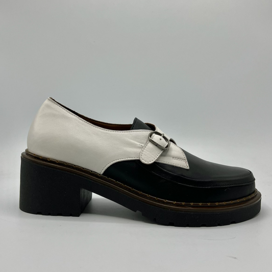 Black and white shoe with a buckle on a gray background