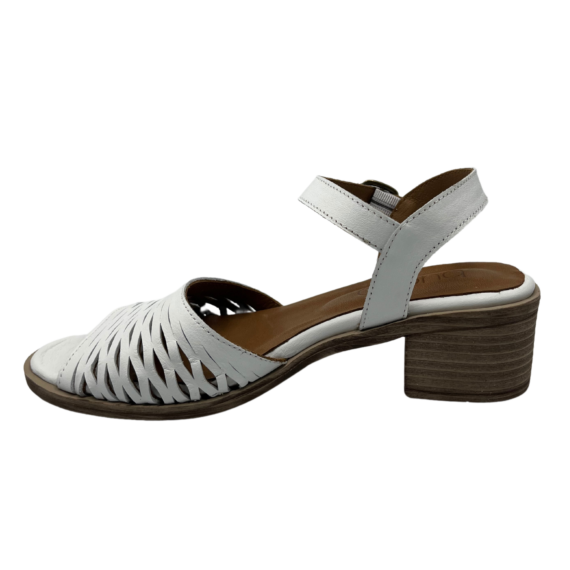 Left facing view of white leather sandal with stacked heel and cutout details on upper