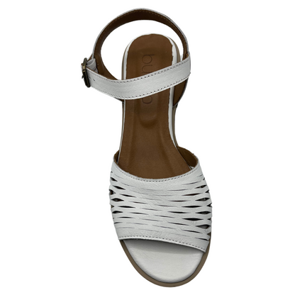 Top view of white leather sandal with cutout details and buckle strap