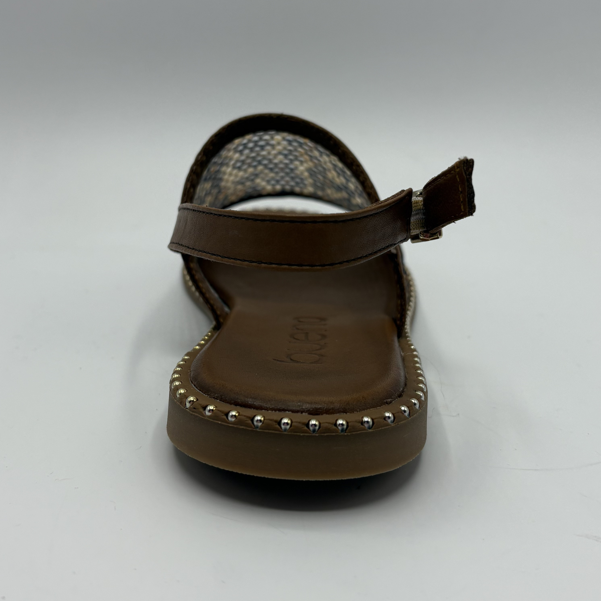 Brown sandal with studded details on a white background
