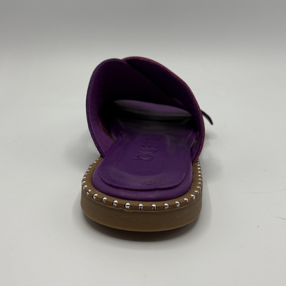 Purple sandal with studded detail on a gray background