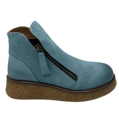 Right facing view of blue leather ankle boot with rubber wedge sole and double zipper closure