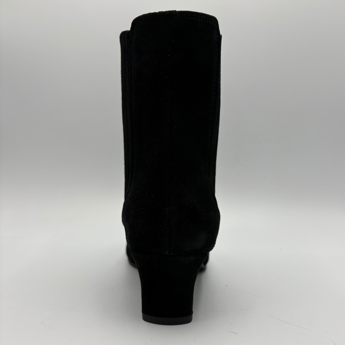 Back view of a black suede ankle boot with a kitten heel and a soft pointed toe