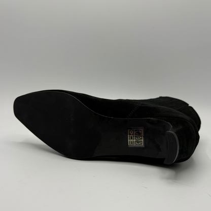 Bottom view of a black suede ankle boot with a kitten heel and a soft pointed toe