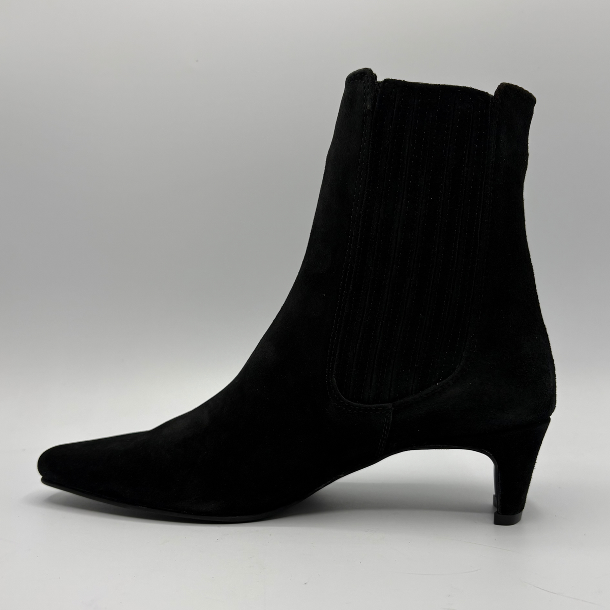 Left view of a black suede ankle boot with a kitten heel and a soft pointed toe