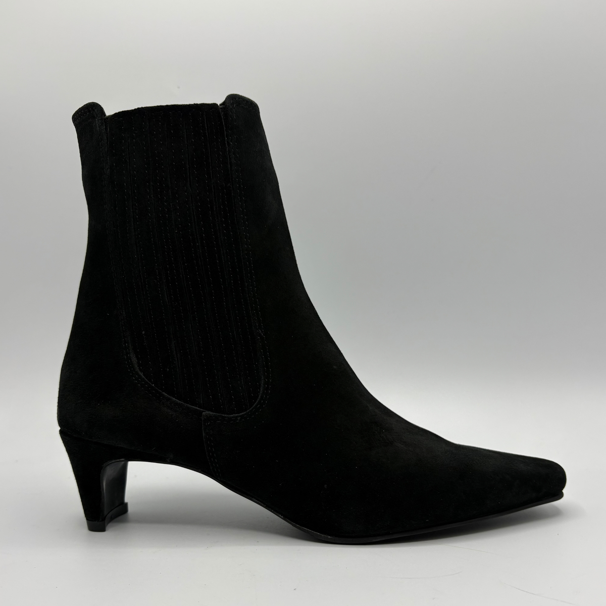 Right facing view of a black suede ankle boot with a kitten heel and a soft pointed toe