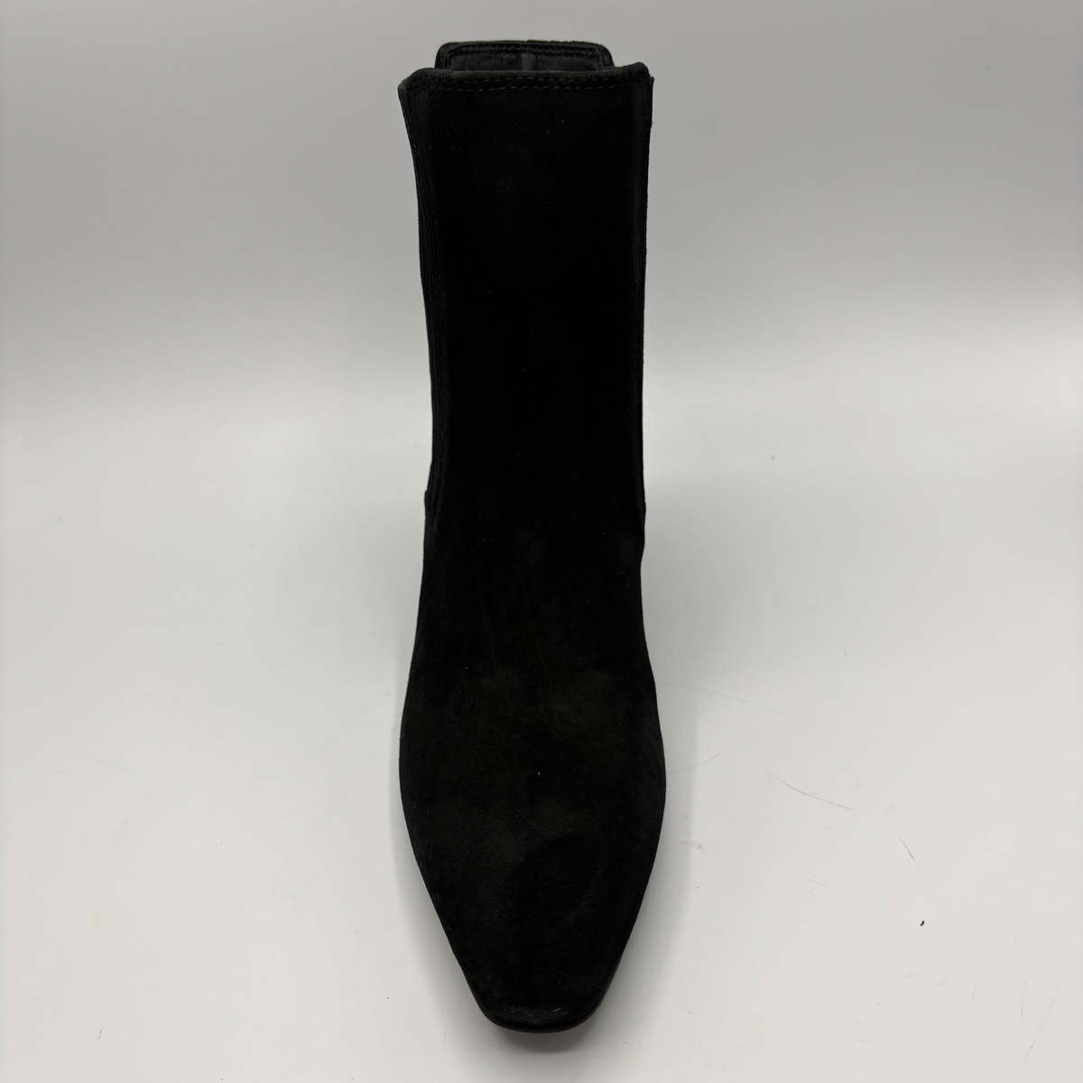Front view of a black suede ankle boot with a kitten heel and a soft pointed toe