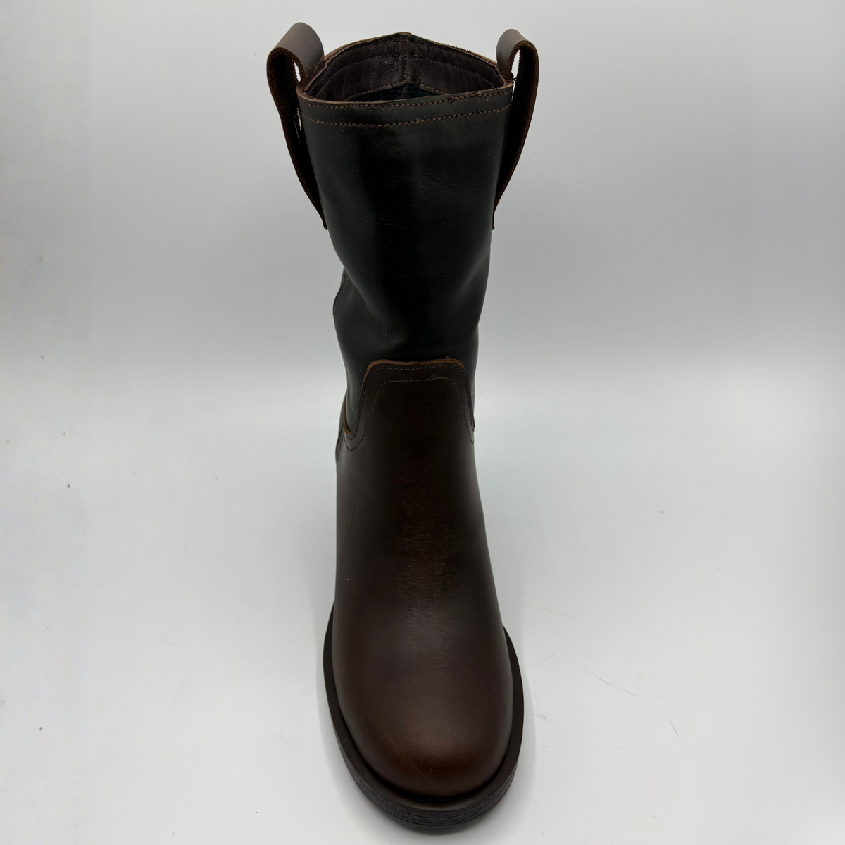 Top view of a brown leather short boot with a stacked heel and gold button accent