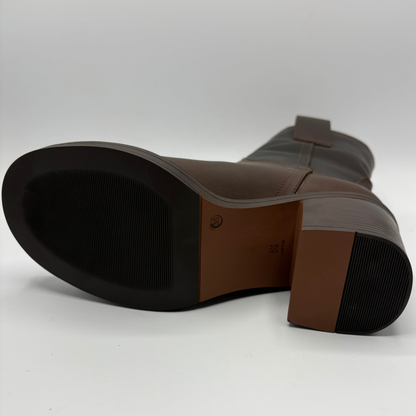 Bottom view of a brown leather short boot with a stacked heel and gold button accent