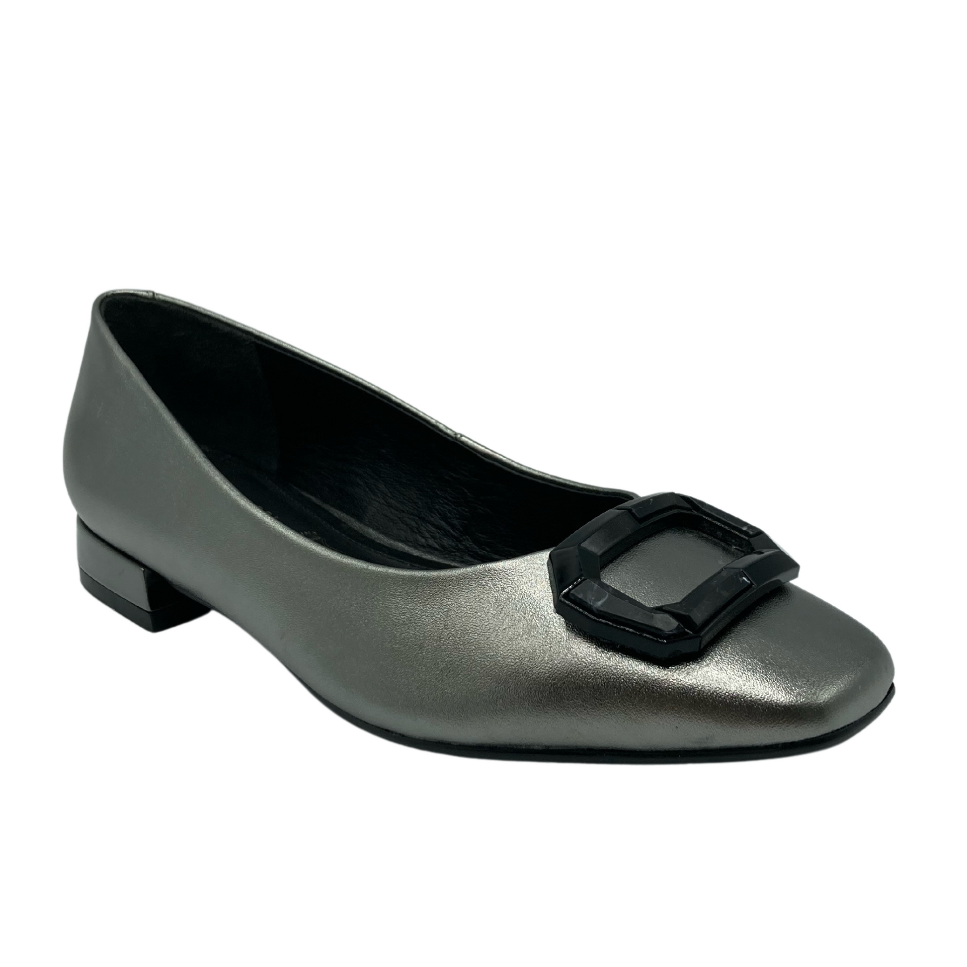 45 degree angled view of metallic silver ballet flat with square toe and black buckle detail on the toe 