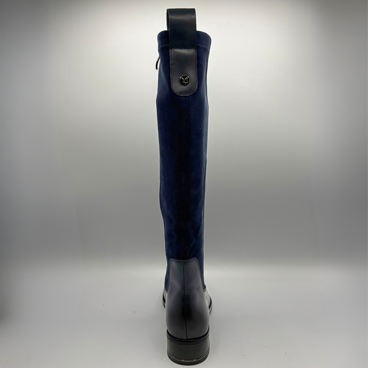Back view of a tall navy boot with an inner zipper closure