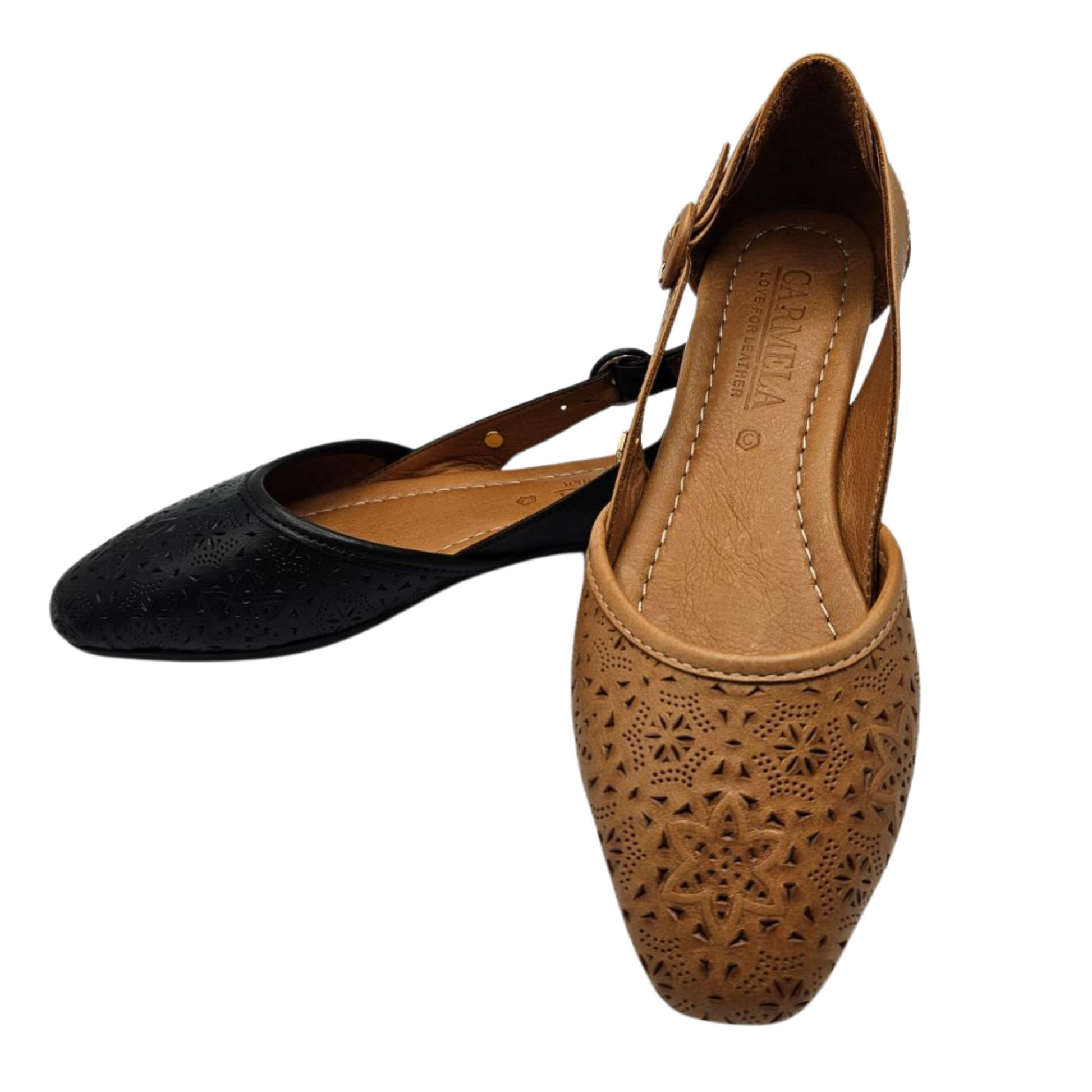 A view of two leather flat shoes. The one in the back ground is black and the one in the foreground is tan. Both have perforated floral designs on the front and adjustable side buckle straps. Slightly pointed toe and leather lined.