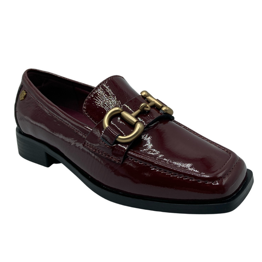 45 degree angled view of square toed burgundy loafer with gold bit detail on upper