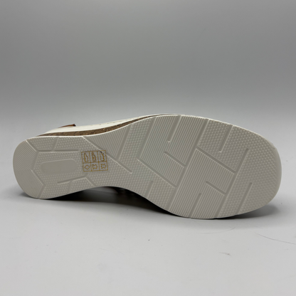 Close-up of a shoe sole with a brand logo on a gray background