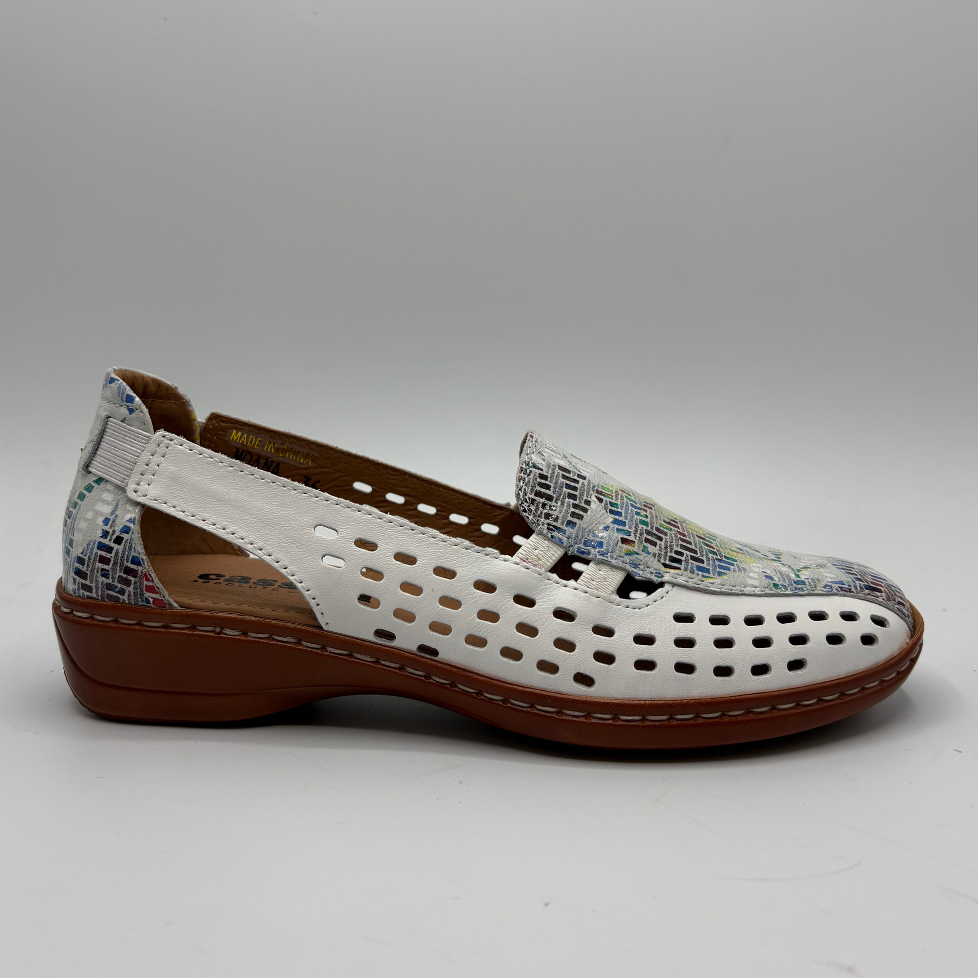 White mixed shoe with brown sole and multicolored strap on a gray background