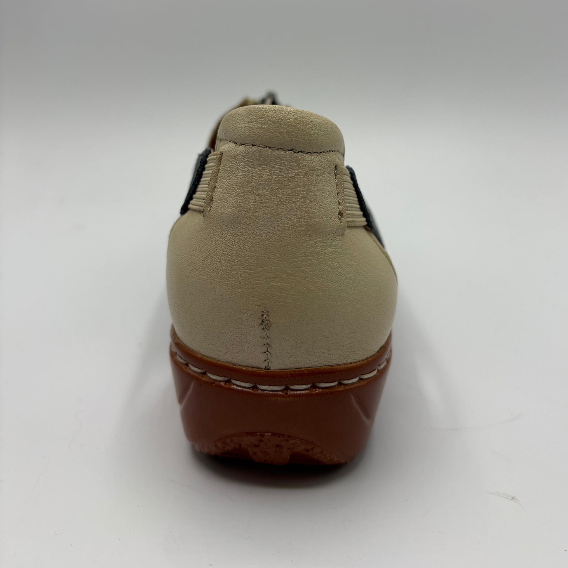 Beige shoe with brown sole on a white background