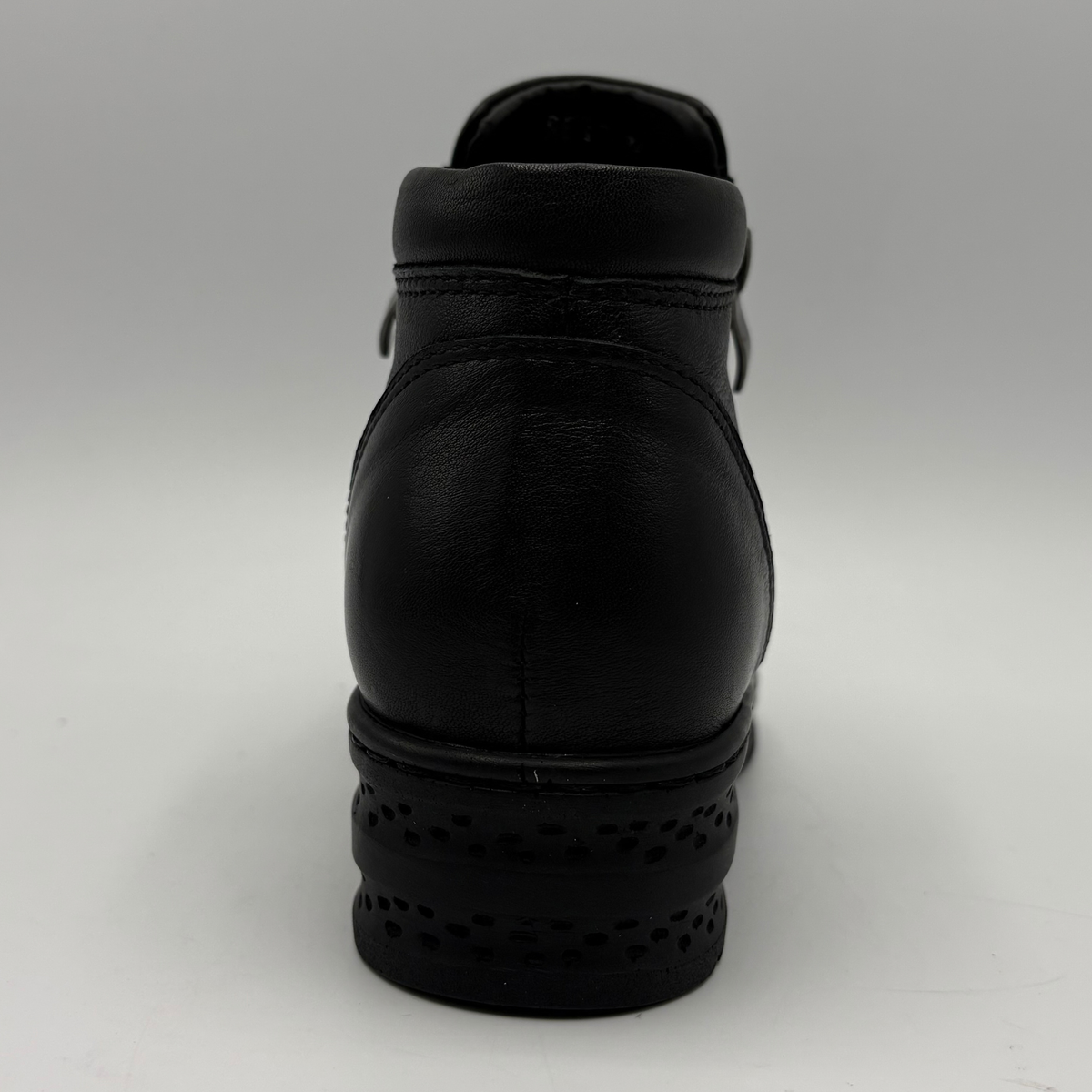 Back view of a black ankle boot with a side zipper closure and slight wedge sole