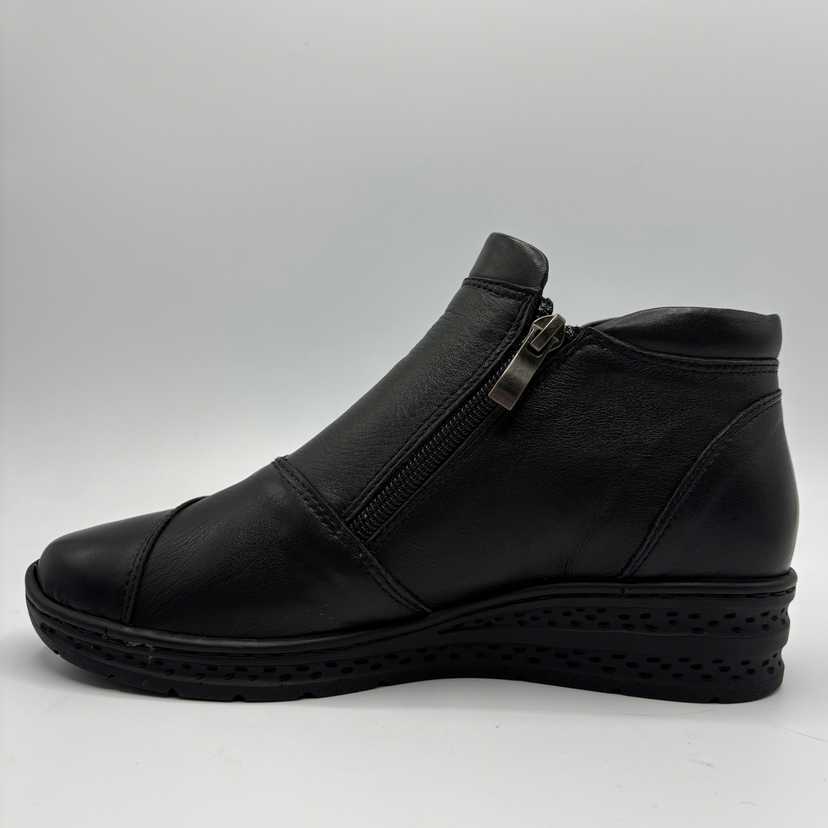 Left facing view of a black ankle boot with a side zipper closure and slight wedge sole