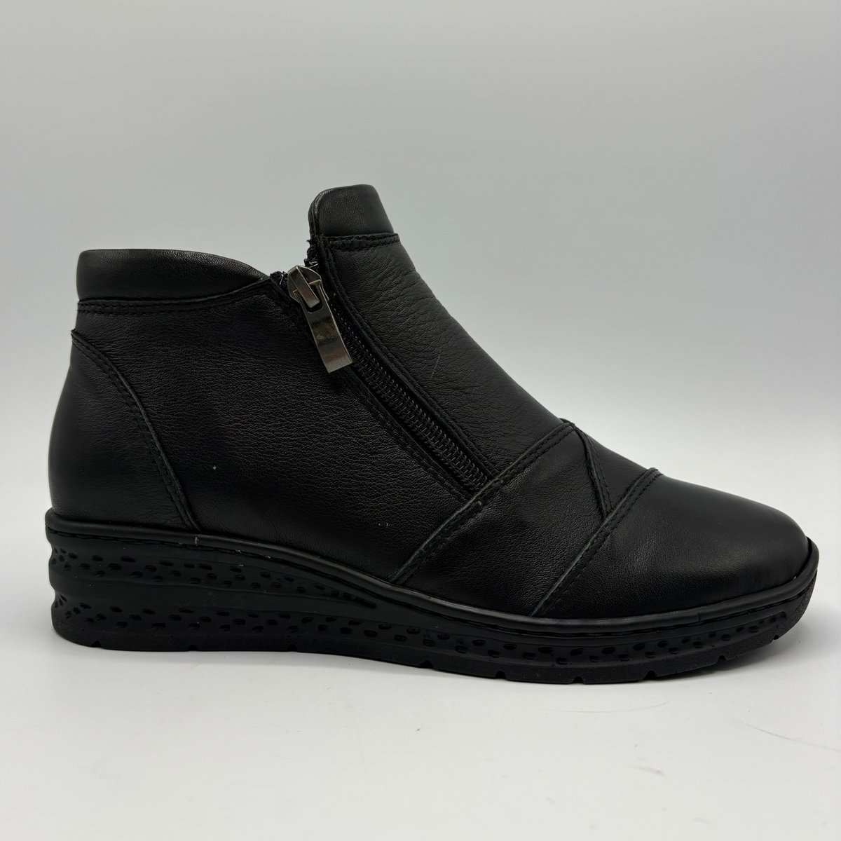 Right facing view of a black ankle boot with a side zipper closure and slight wedge sole