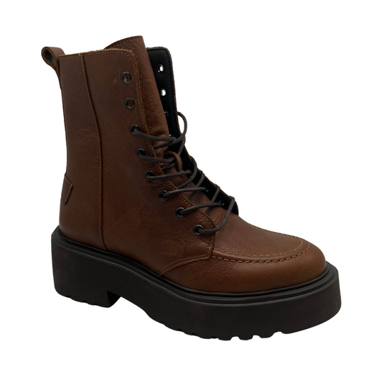 45 degree angled view of brown leather short boot with lug rubbed outsole, dark laces, pull on heel tab and side zipper closure