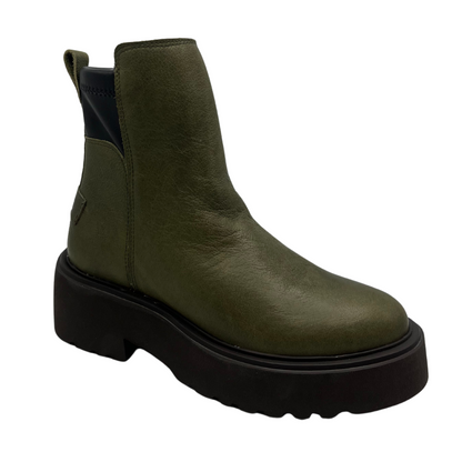 45 degree angled view of a khaki leather ankle boot with pull on heel tab and black lightweight lug sole