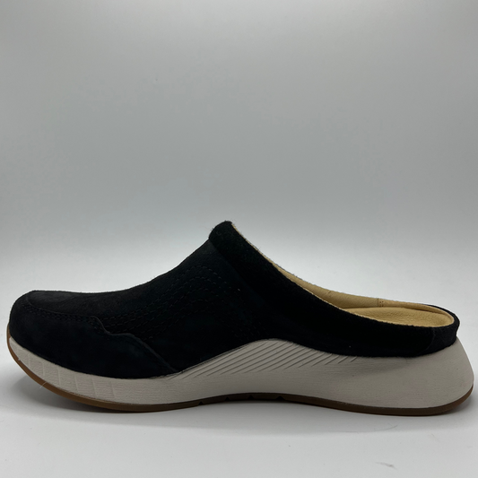 Black slip-on shoe with white sole on a gray background