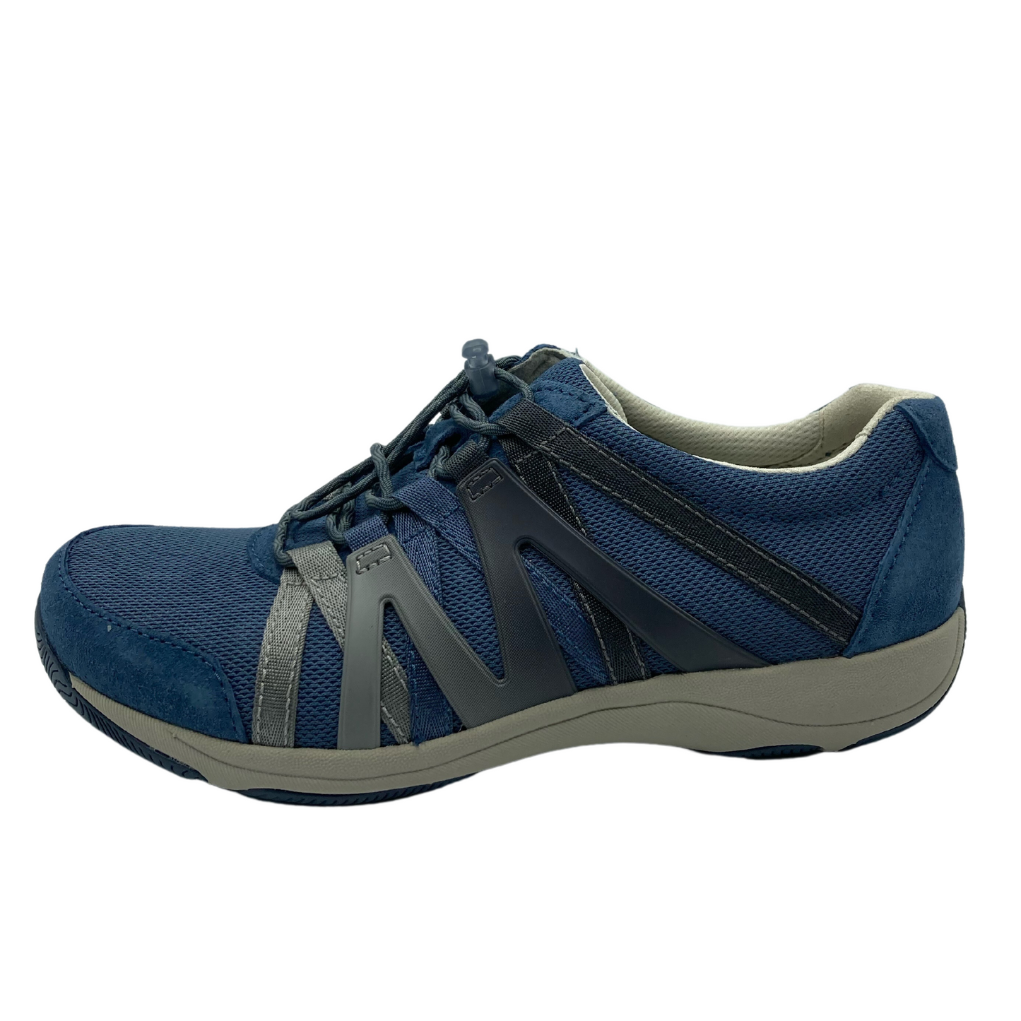 A left side profile of a blue sneaker. The shoe has a white and blue rubber sole, a mesh top, suede detailing, and an Ombre zig-zagged side pattern.