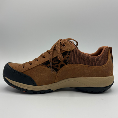 A brown low-top sneaker with a leopard-print pattern panel, black toe cap and outsole, and a beige midsole, shown from the side on a white background.