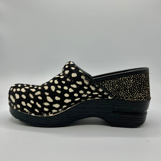 Black clog shoe with white polka dot pattern on a gray background
