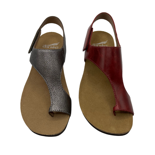 Top view of two leather strapped sandals with velcro ankle strap. The left one is metallic pewter and the right one is dark red and both have brown lining