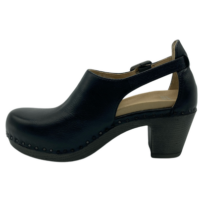 Left facing view of black leather clog with chunky heel and buckle strap detail