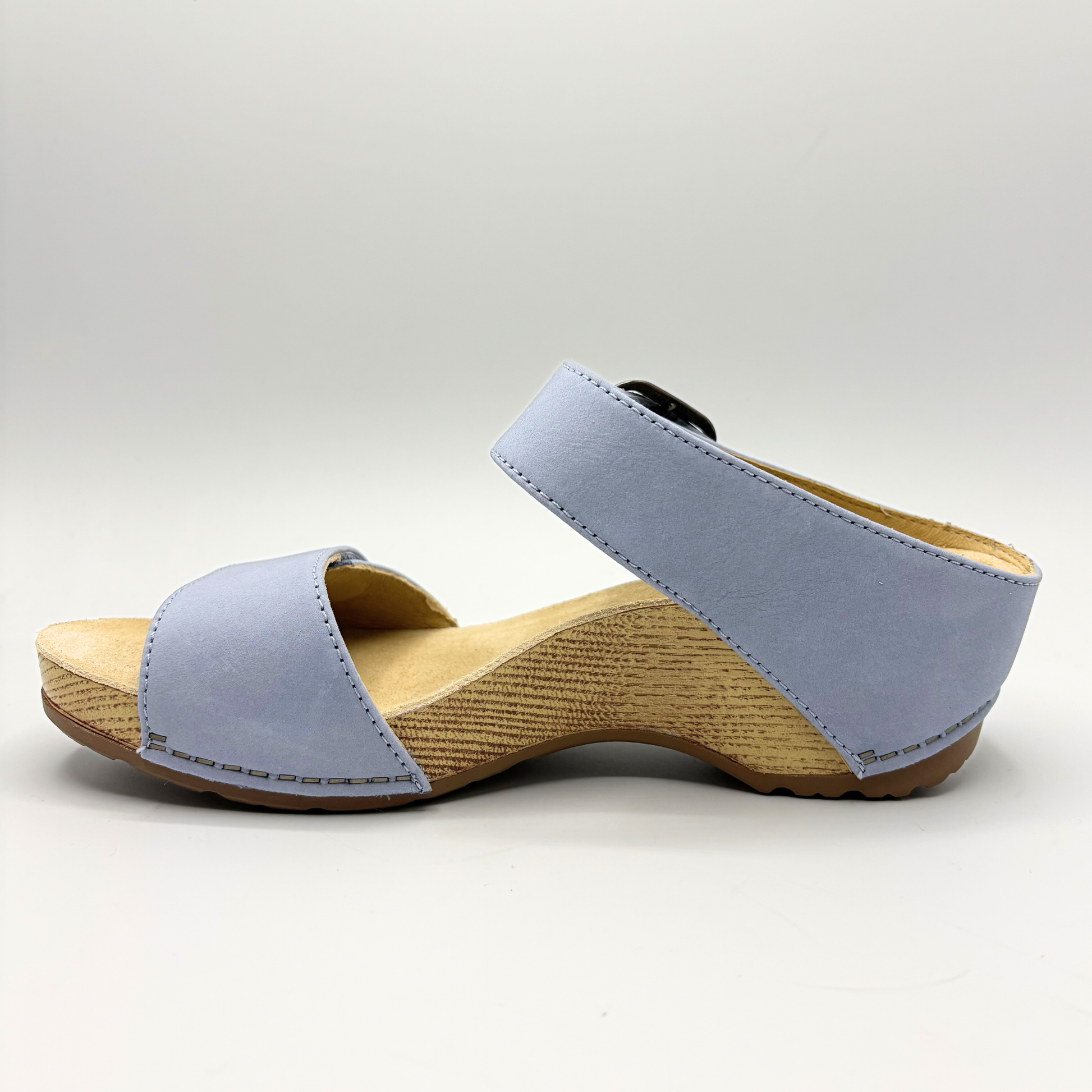 Wedge sandal with light blue strap and wooden sole on a white background
