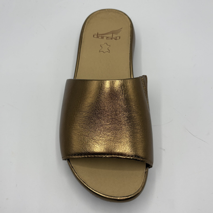 Gold sandal with 'Dansko' branding on a white background
