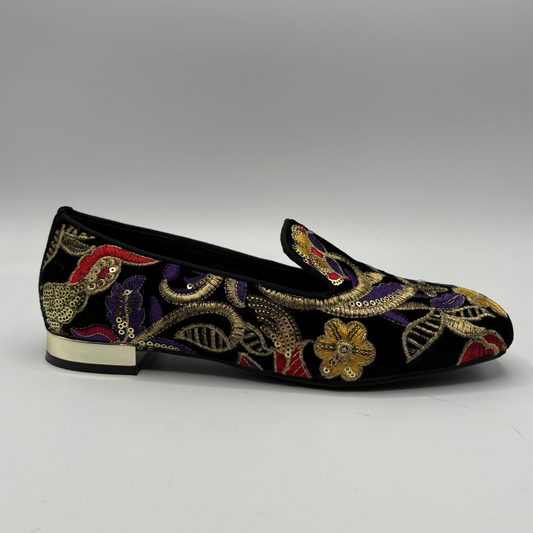 A single black velvet loafer flat with intricate gold, purple, and red floral and paisley embroidery, featuring a low block heel with a gold accent.
