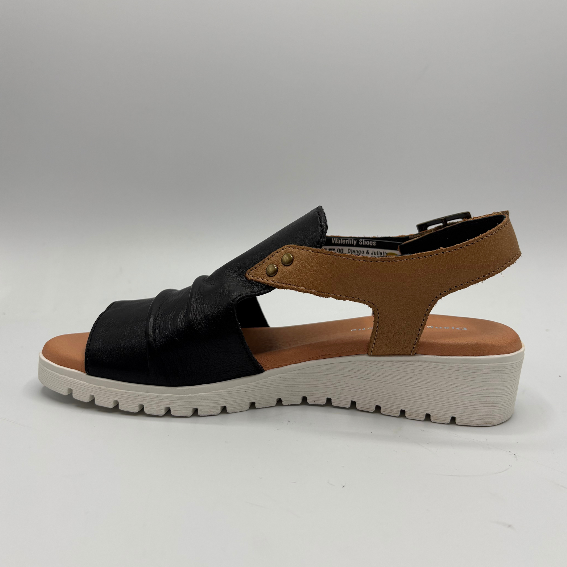 Black and brown sandal with a white sole on a gray background
