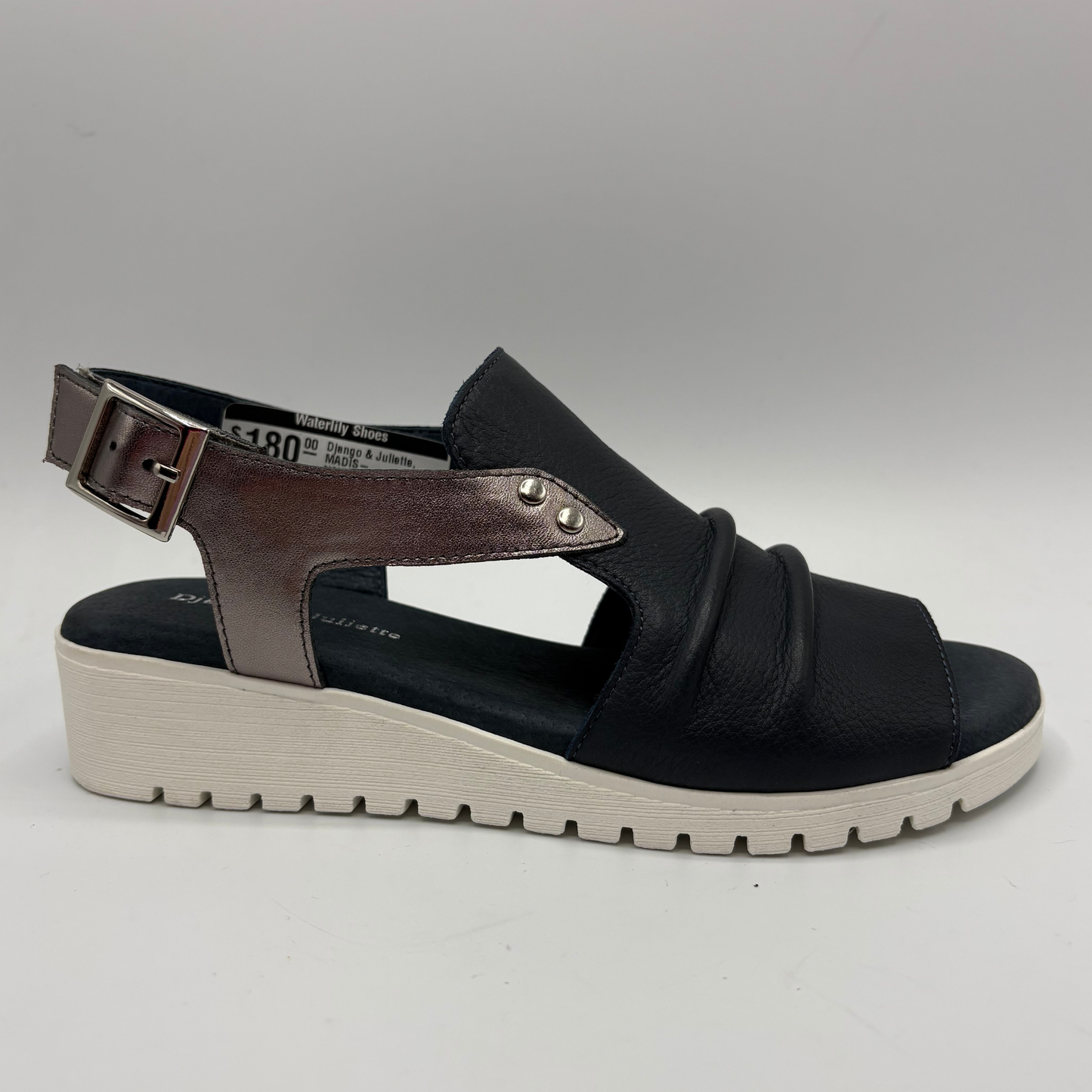 Black sandal with brown strap on a gray background