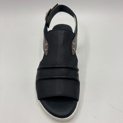Black sandal with multiple straps on a light gray background