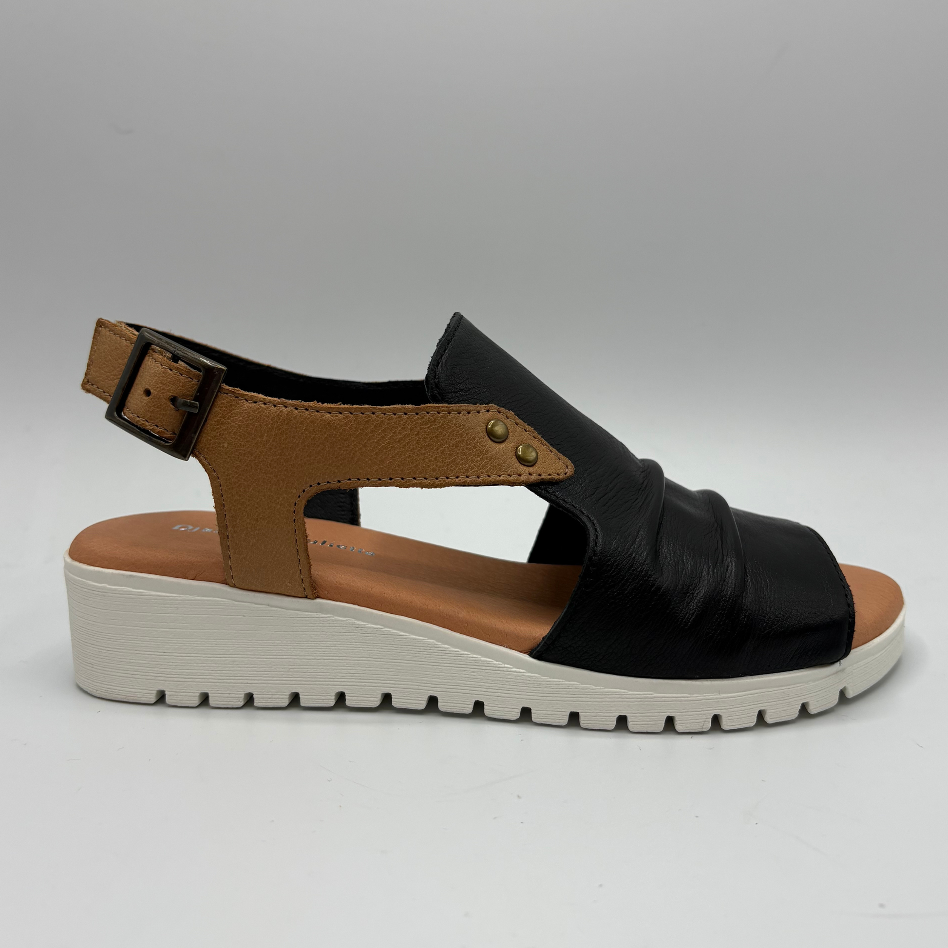 Black sandal with brown straps on a gray background