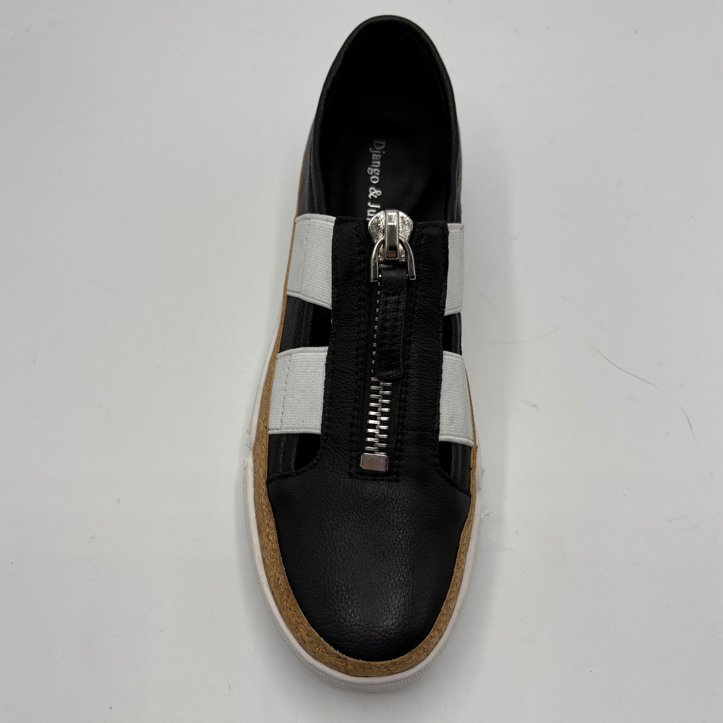 Black shoe with a silver zipper on a light gray background