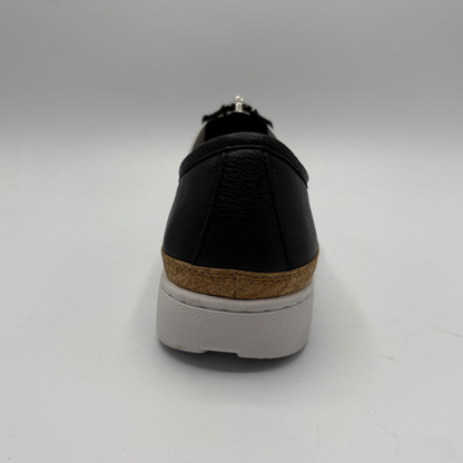 Black shoe with a cork sole on a white background