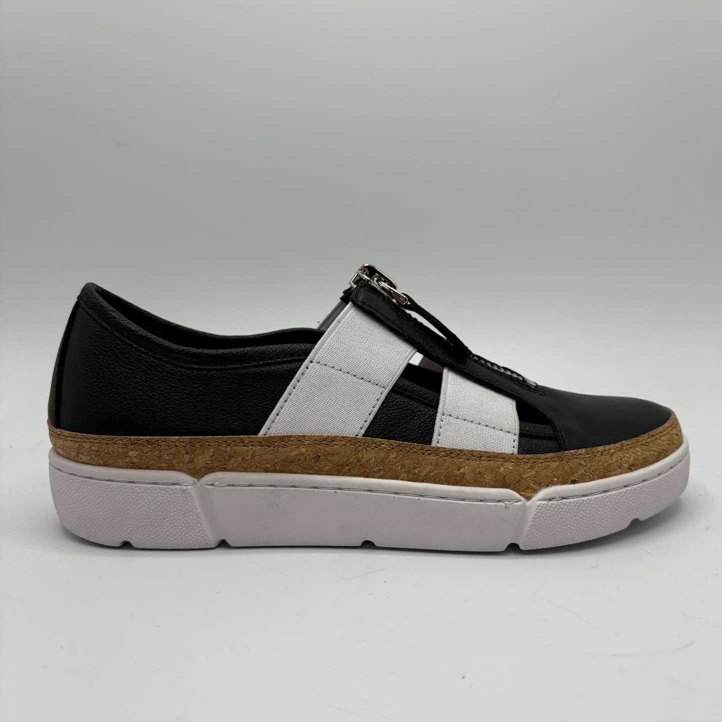 Black and white sneaker with a brown sole on a gray background