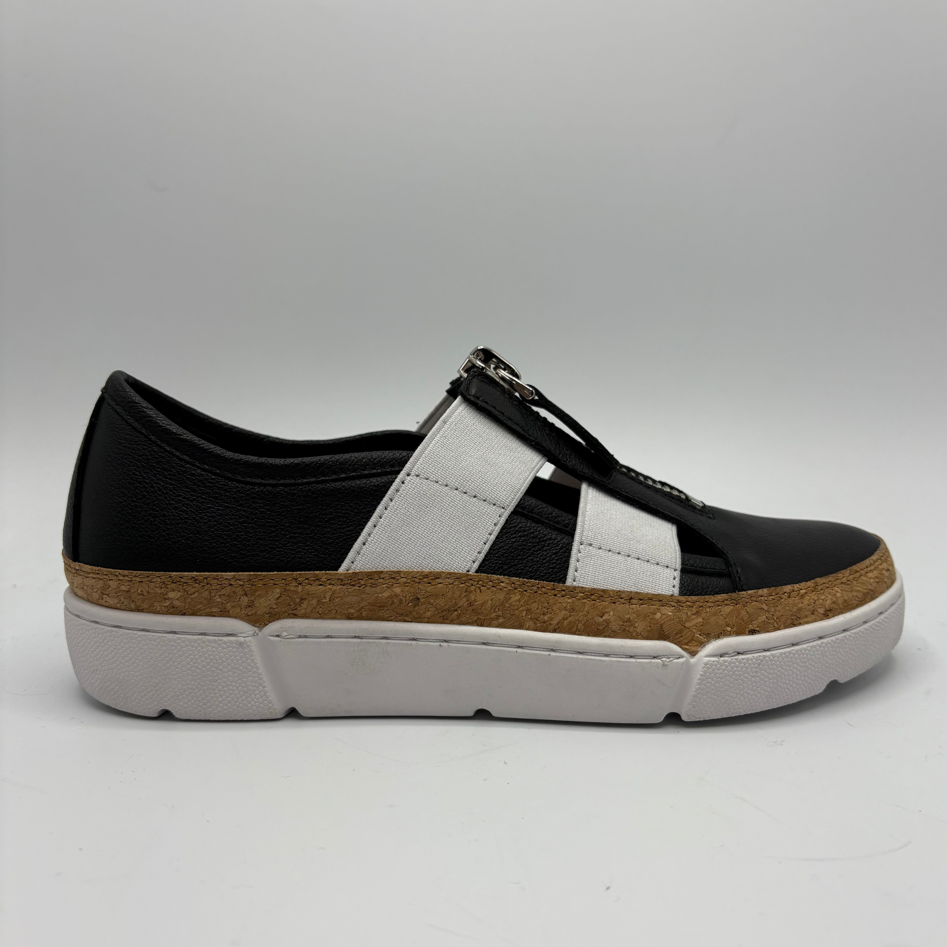 Black and white sneaker with a brown sole on a gray background