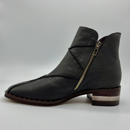 Left facing view of a leather ankle boot with a gold zipper